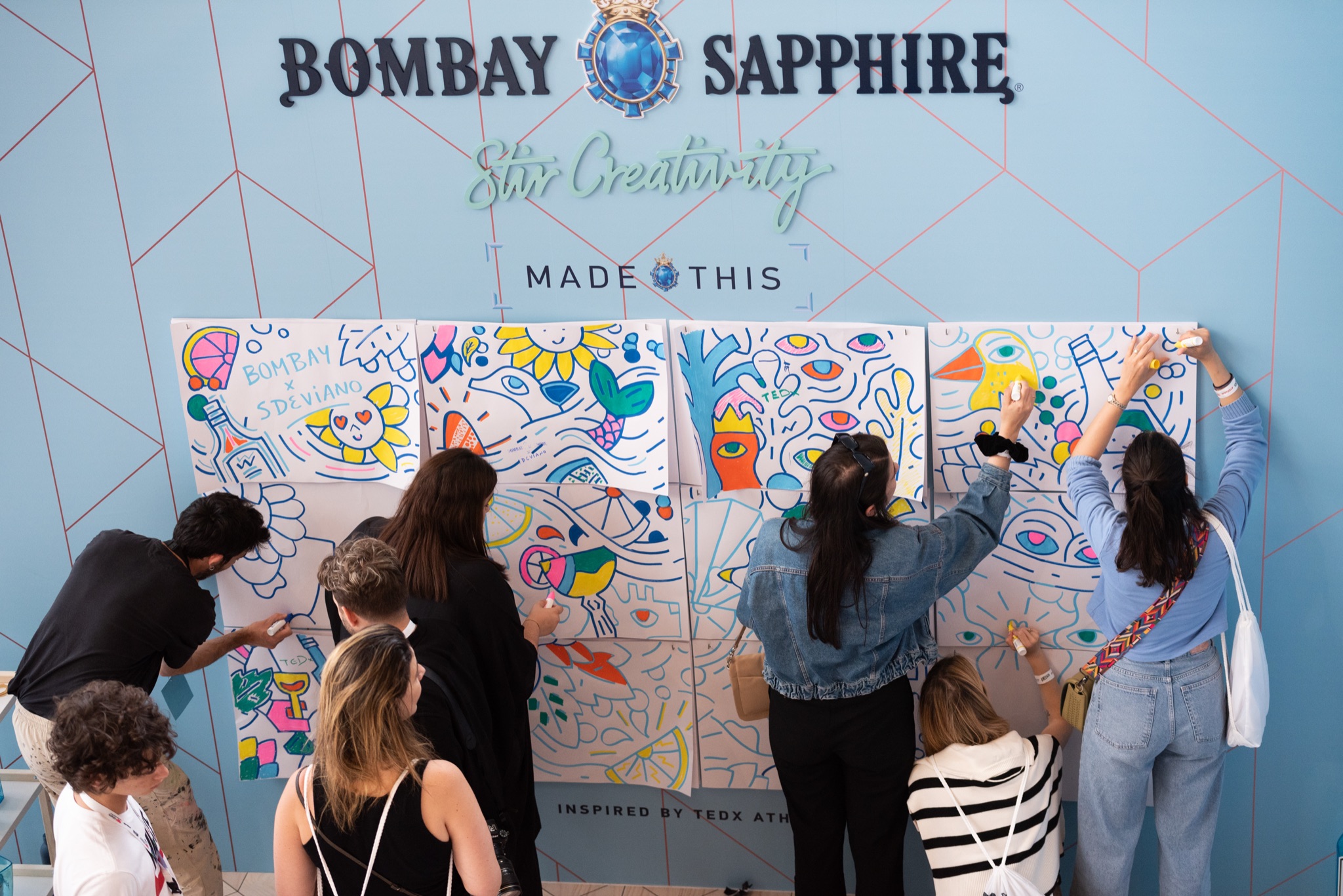 Attendees colouring in the sheets on the Bombay Sapphire wall
