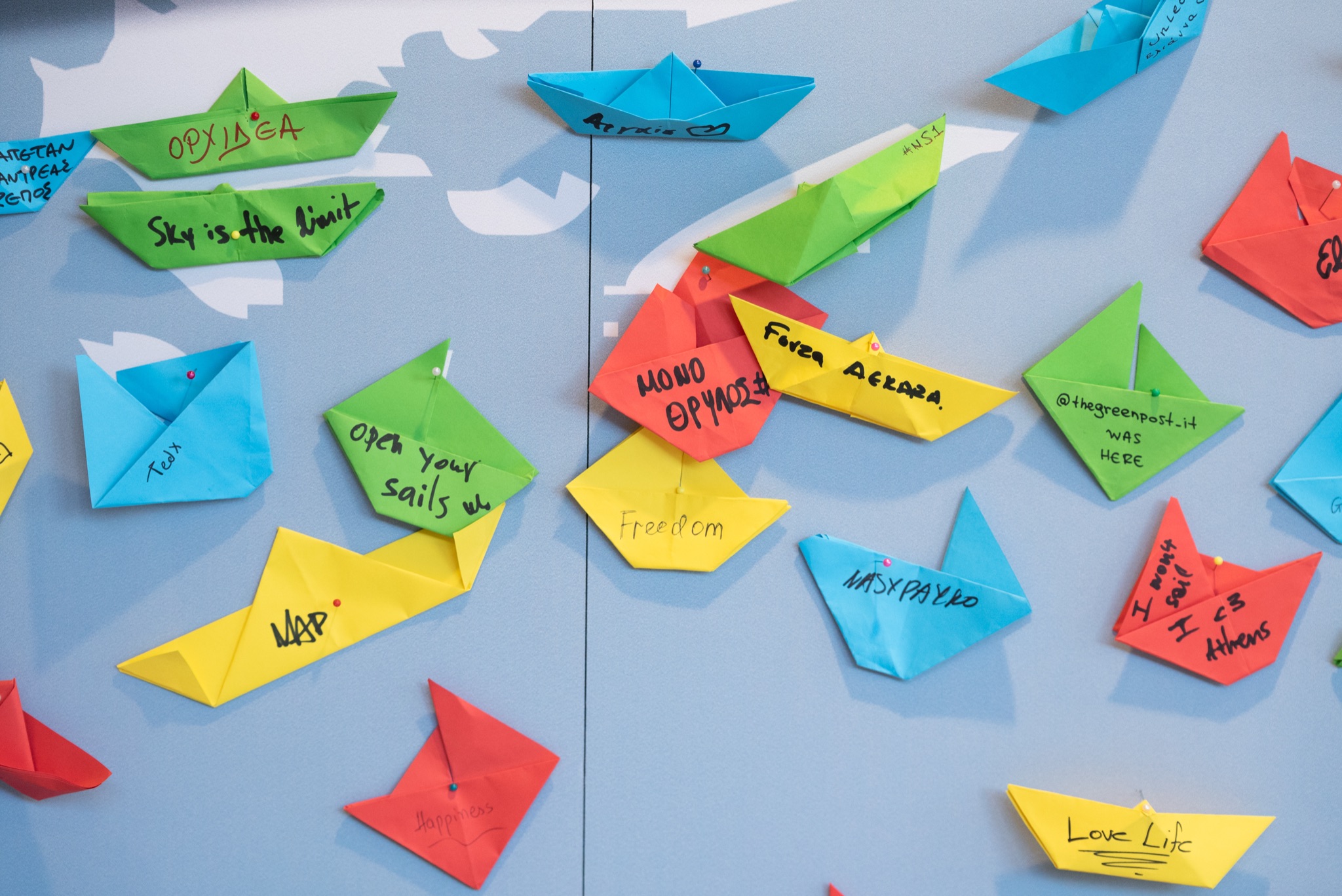 Folded paper boats pinned to the chart, names and wishes written on them