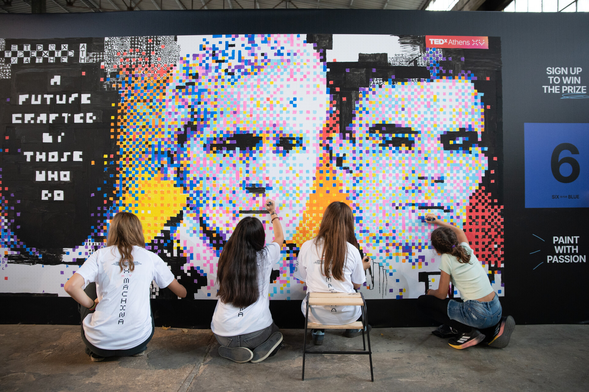 Volunteers filling the mosaic grid at the wall